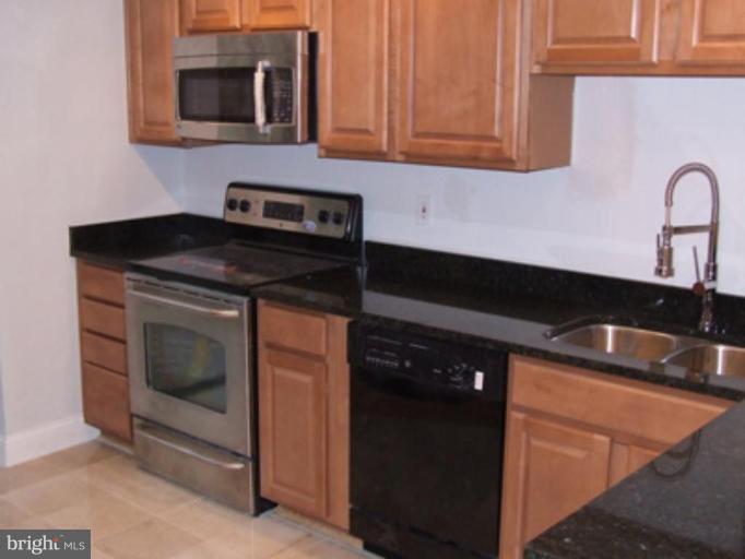 11186 Saffold Way Reston, VA 20190 - Photo 2 of 15 a kitchen with granite countertop white cabinets and black appliances
