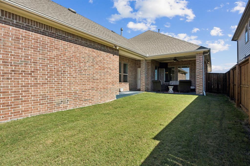 8905 Habersham Drive Rowlett, TX 75089 - Photo 25 of 31 Back of property with ceiling fan, brick siding, a patio area, roof with shingles, and a fenced backyard