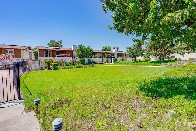a view of a house with a big yard and potted plants
