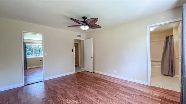 a view of room with window ceiling fan and hardwood floor