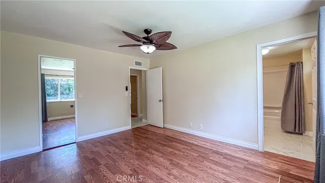 a view of room with window ceiling fan and hardwood floor