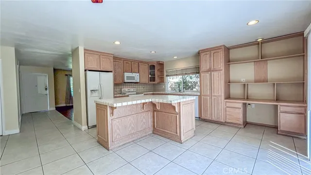a kitchen with granite countertop a stove a sink and a refrigerator