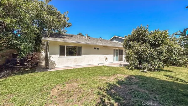 a backyard of a house with garden and outdoor seating