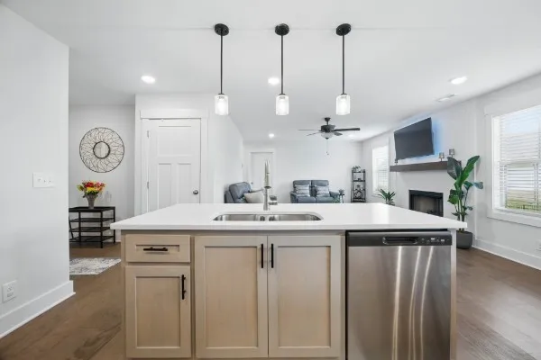 a kitchen with kitchen island a sink a stove a oven a dining table and chairs