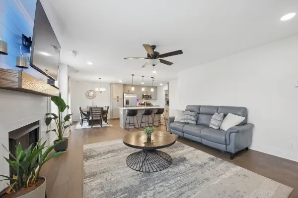 a living room with furniture a fireplace and a chandelier