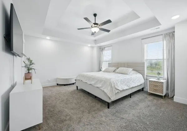 a bedroom with a bed and a flat tv screen on the dresser