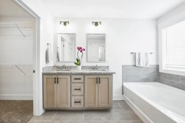 a bathroom with a granite countertop sink and a bathtub