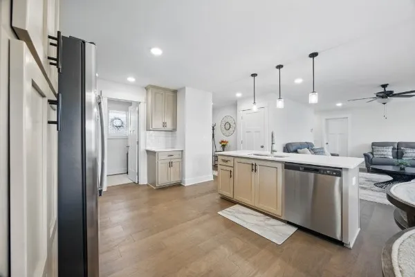 a kitchen with stainless steel appliances kitchen island a refrigerator sink and cabinets