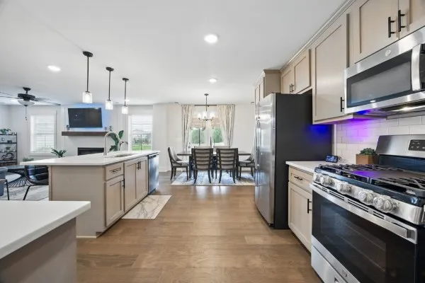 a kitchen with stainless steel appliances kitchen island granite countertop a stove a sink a refrigerator and a microwave