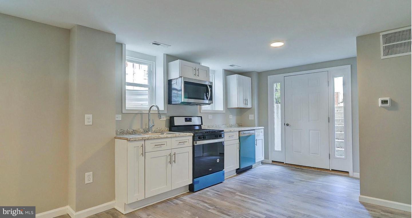 6110 41st Avenue, Unit C Hyattsville, MD 20782 - Photo 3 of 11 a kitchen with a sink cabinets stainless steel appliances and a window