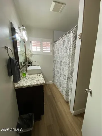 a view of hallway with window and wooden floor