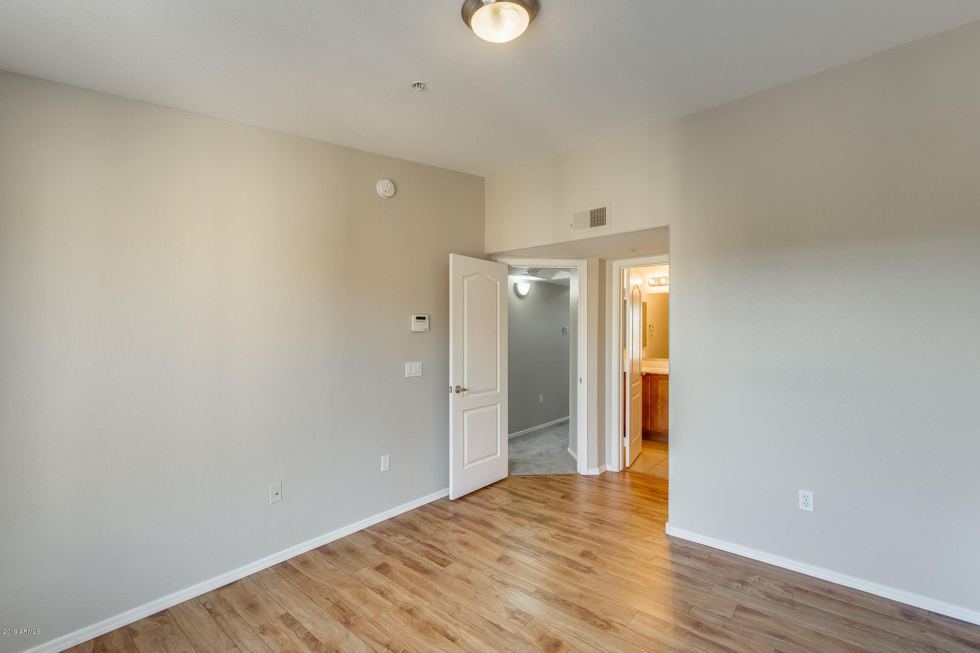 2401 East Rio Salado Parkway, Unit 1124 Tempe, AZ 85288 - Photo 25 of 32 a view of an empty room with wooden floor and windows