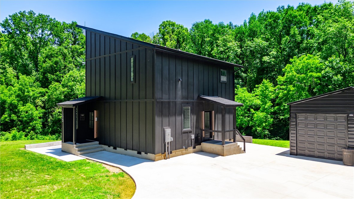 159 Cherokee Trail Easley, SC 29640 - Photo 26 of 38 A modern black structure with an attached garage is nestled among verdant trees.