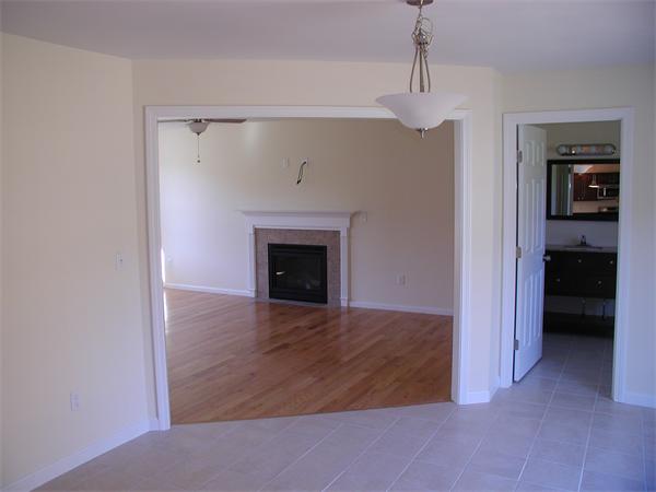 143 Lowell Road Salem, NH 03079 - Photo 4 of 9 a view of an empty room with a fireplace and a window