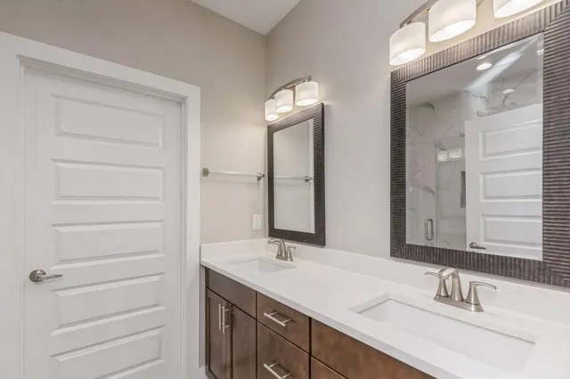 a bathroom with a double vanity sink and a mirror