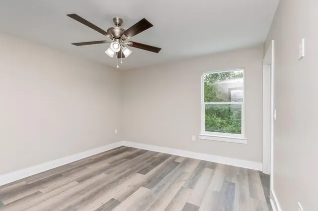 an empty room with a window and a fan