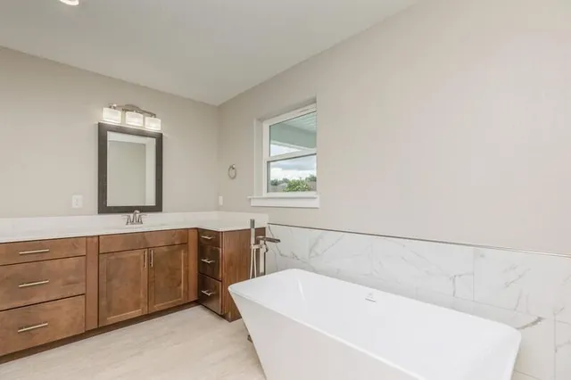a bathroom with a large tub sink and vanity