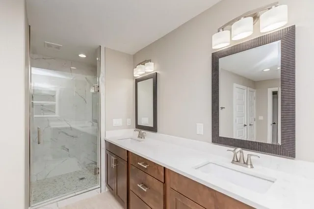 a bathroom with a shower sink and a mirror