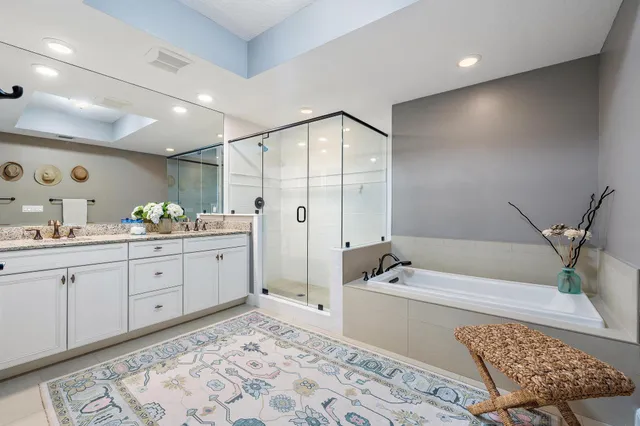a spacious bathroom with a double vanity sink a mirror and a bathtub