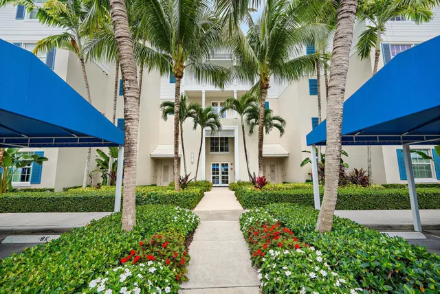 a front view of a house with garden and plants