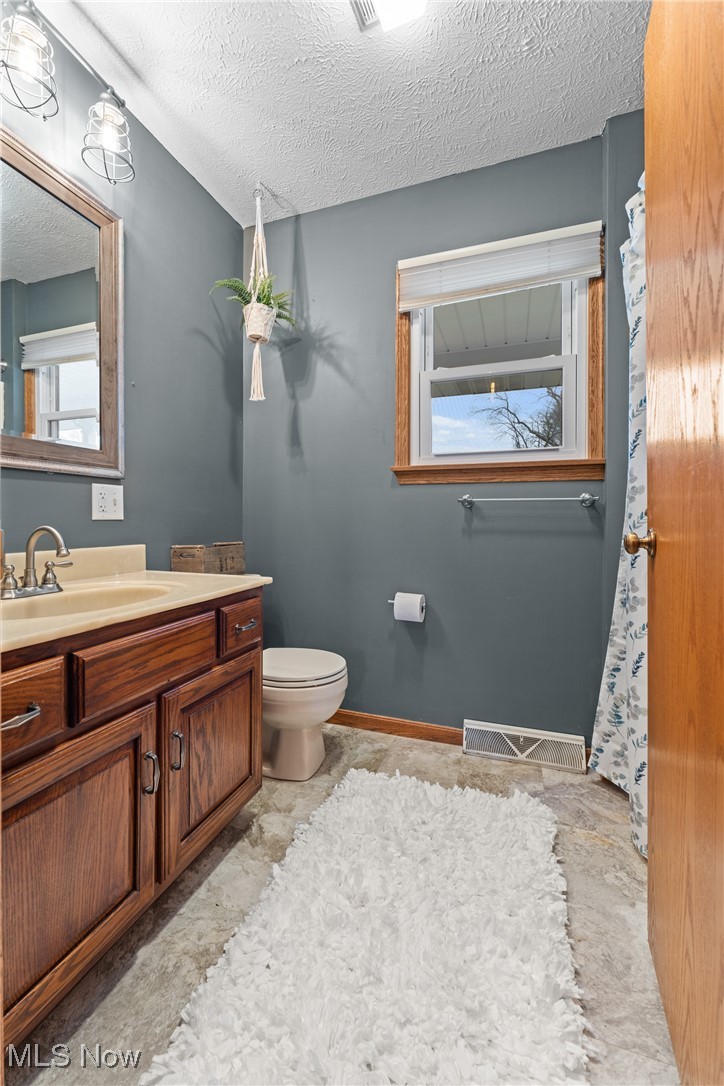 645 Killinger Road Clinton, OH 44216 - Photo 32 of 50 Bathroom with vanity, a textured ceiling, and toilet