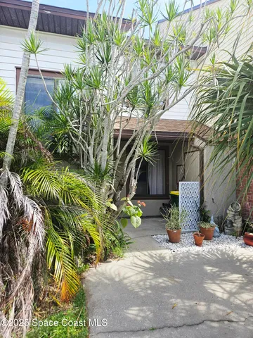a view of a brick house with a small yard and plants