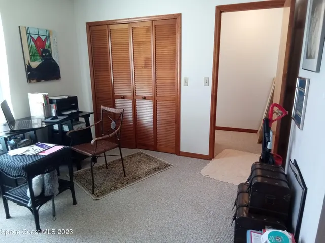 a view of a workspace with furniture and a window