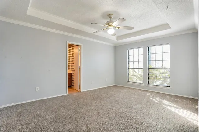 a view of an empty room with a chandelier fan
