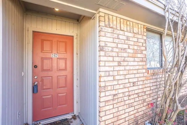 a view of a house with a yard and large tree