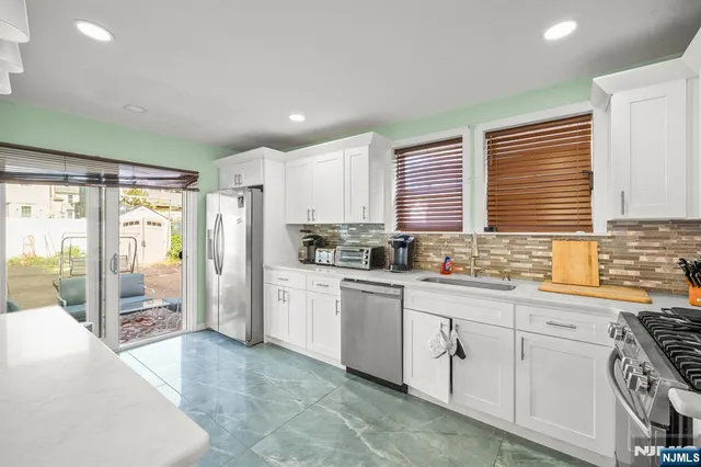 a kitchen with white cabinets and white appliances