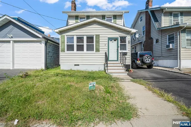 a view of a house with a small yard and potted plants