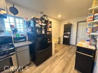 a kitchen with stainless steel appliances kitchen island granite countertop a refrigerator and a sink