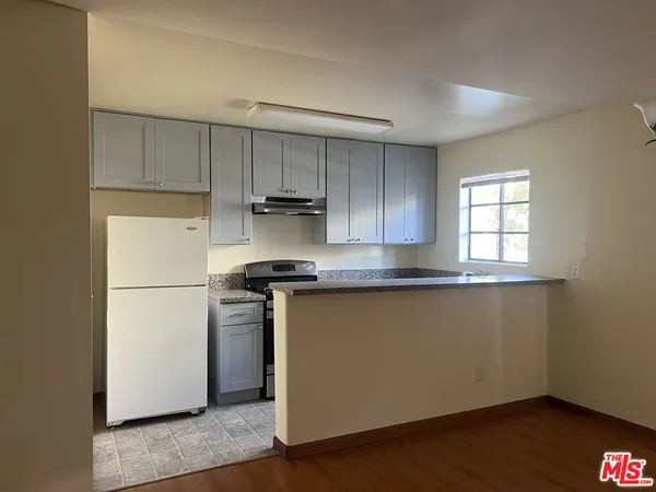 a kitchen with a refrigerator sink and cabinets