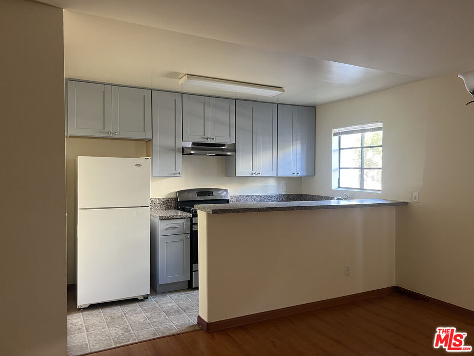 331 South Gramercy Place, Unit 101 Los Angeles, CA 90020 - Photo 2 of 7 a kitchen with a refrigerator sink and cabinets