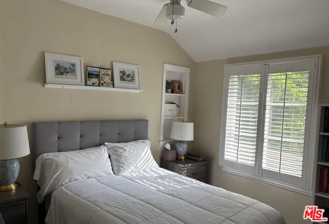 a bedroom with a bed and a large window