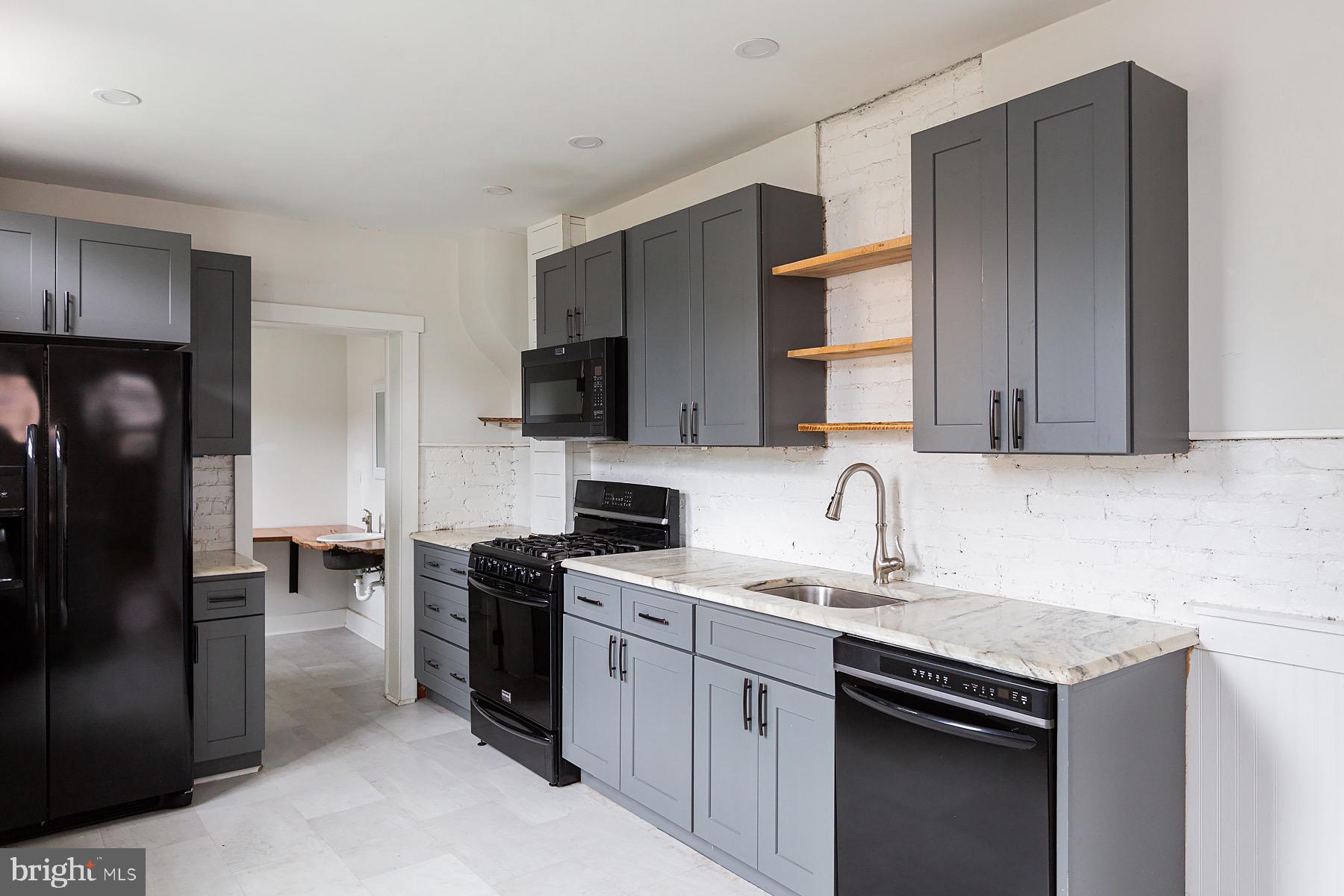 138 Laurel Street Lancaster, PA 17603 - Photo 12 of 42 a kitchen with a sink a microwave a refrigerator and cabinets