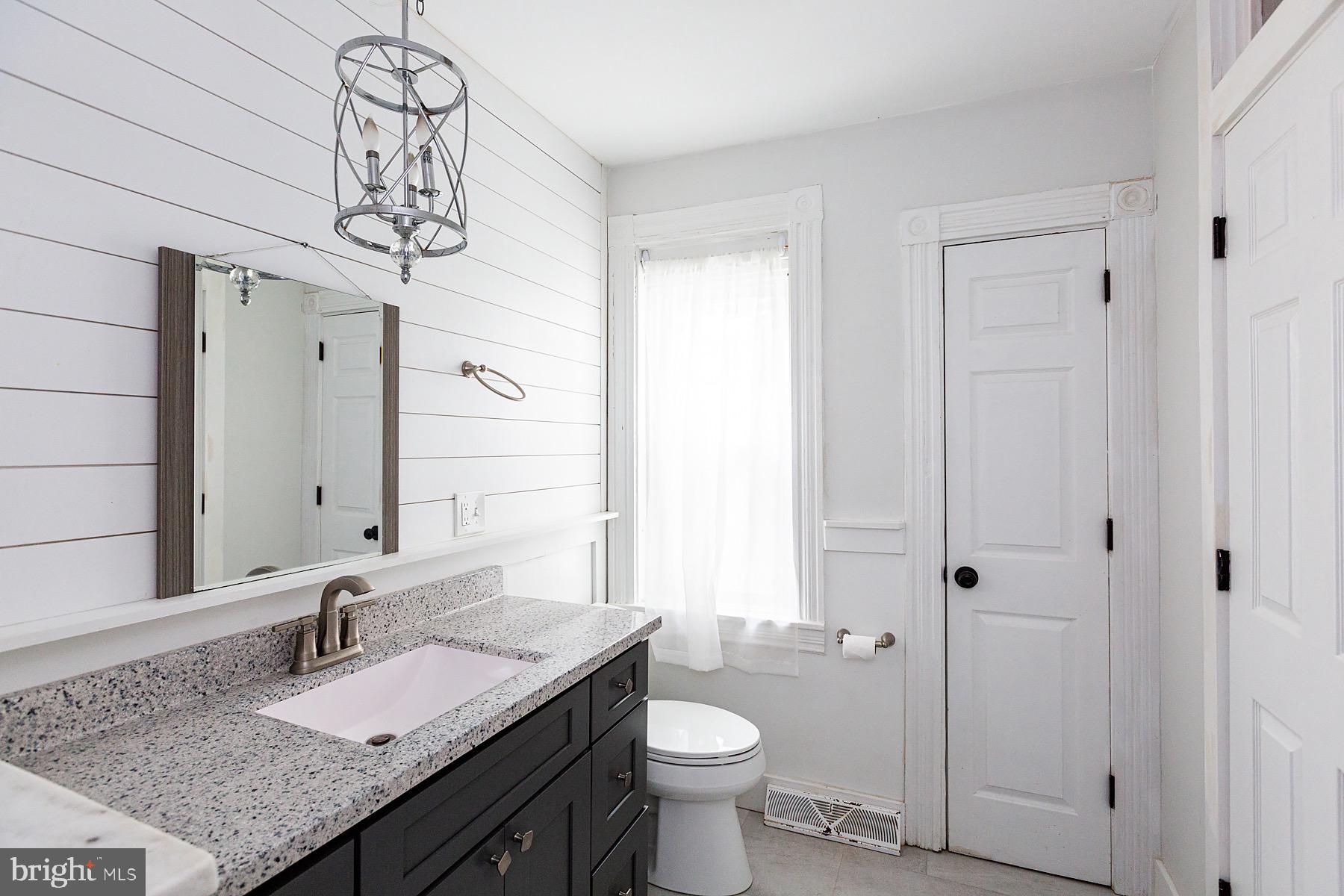138 Laurel Street Lancaster, PA 17603 - Photo 35 of 42 a bathroom with a granite countertop sink a toilet and mirror