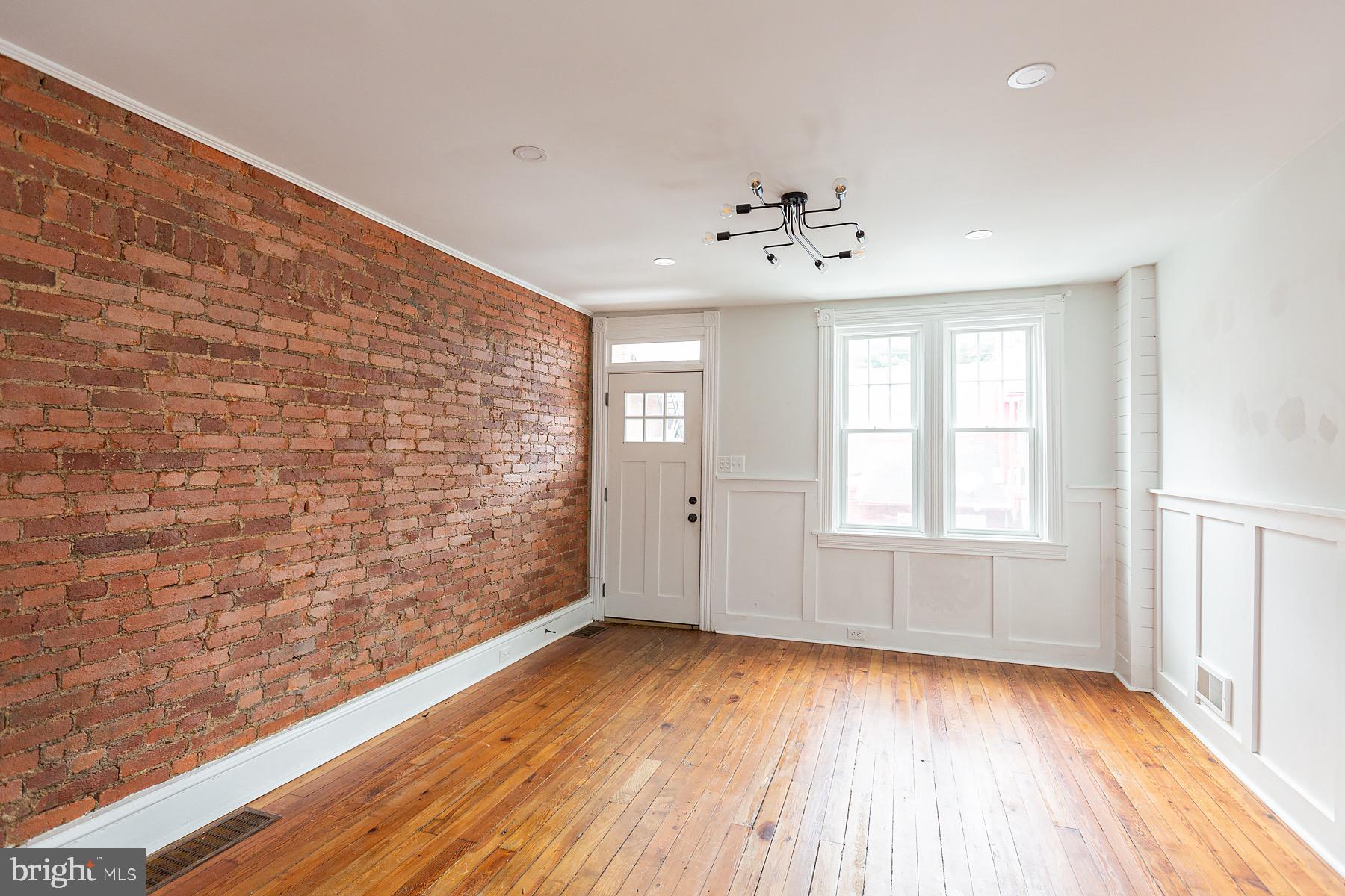 138 Laurel Street Lancaster, PA 17603 - Photo 7 of 42 a view of an empty room with a window and wooden floor