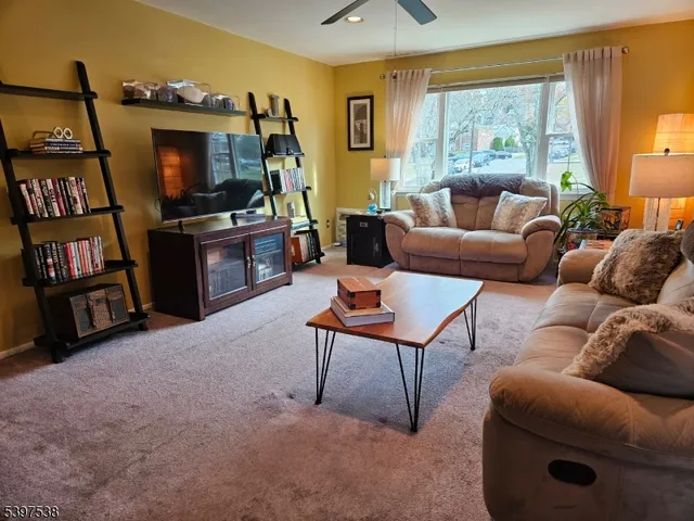 a living room with furniture a window and a flat screen tv