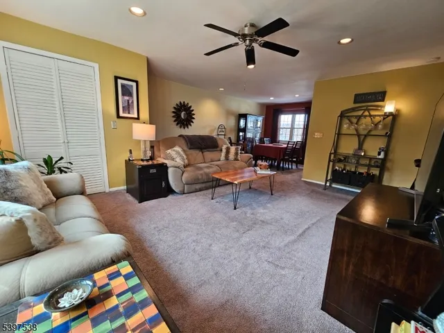 a living room with furniture and a flat screen tv with kitchen view