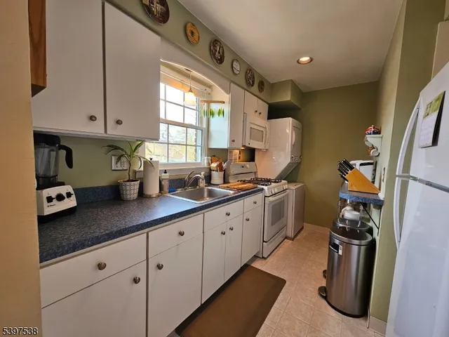 a kitchen with a sink appliances cabinets and a window