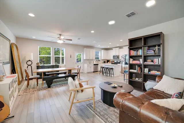a living room with furniture a wooden floor and a book shelf