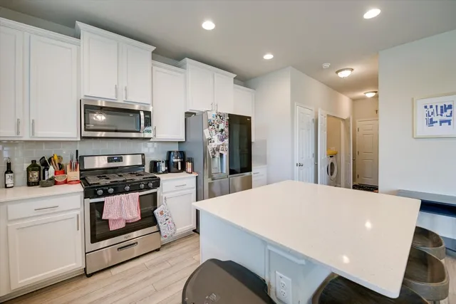 a kitchen with stainless steel appliances a stove a sink a refrigerator and cabinets