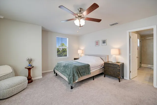 a spacious bedroom with a bed and a chandelier