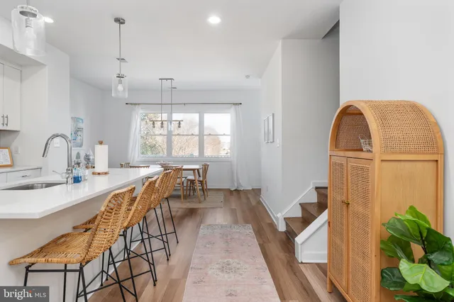 a large white kitchen with lots of counter space a sink appliances and cabinets