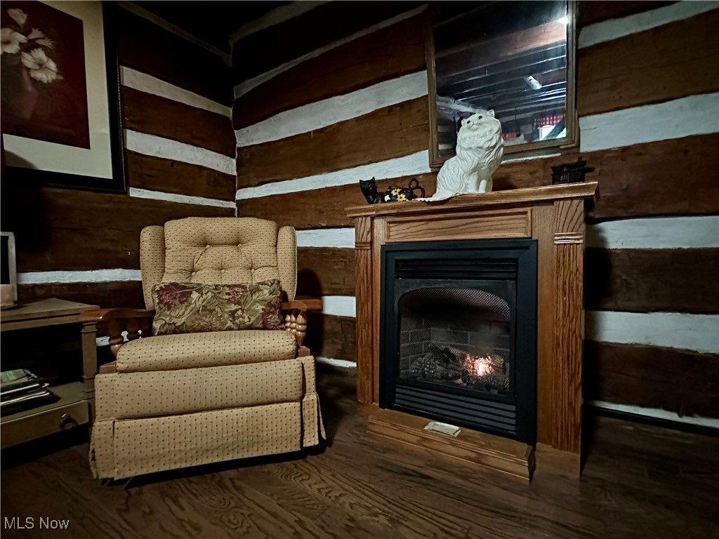 325 North Fork Road New Matamoras, OH 45767 - Photo 49 of 50 Sitting room with wooden walls, a warm lit fireplace, and dark wood-style flooring