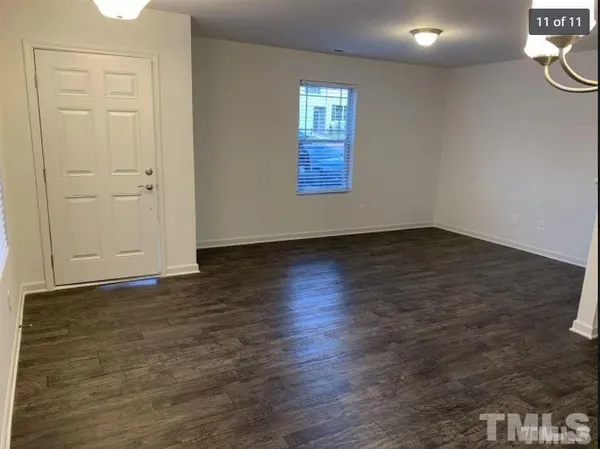 an empty room with wooden floor and window