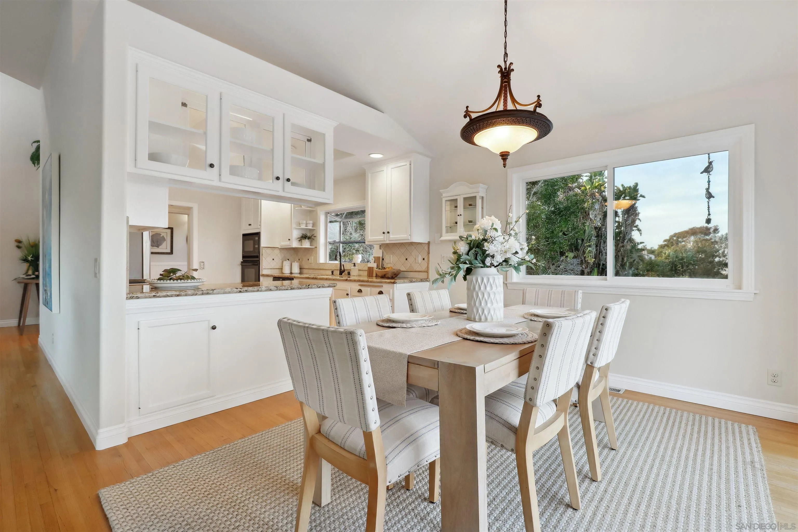 1449 Rainbow Ridge Lane Encinitas, CA 92024 - Photo 11 of 58 a dining room with stainless steel appliances a dining table chairs and large windows