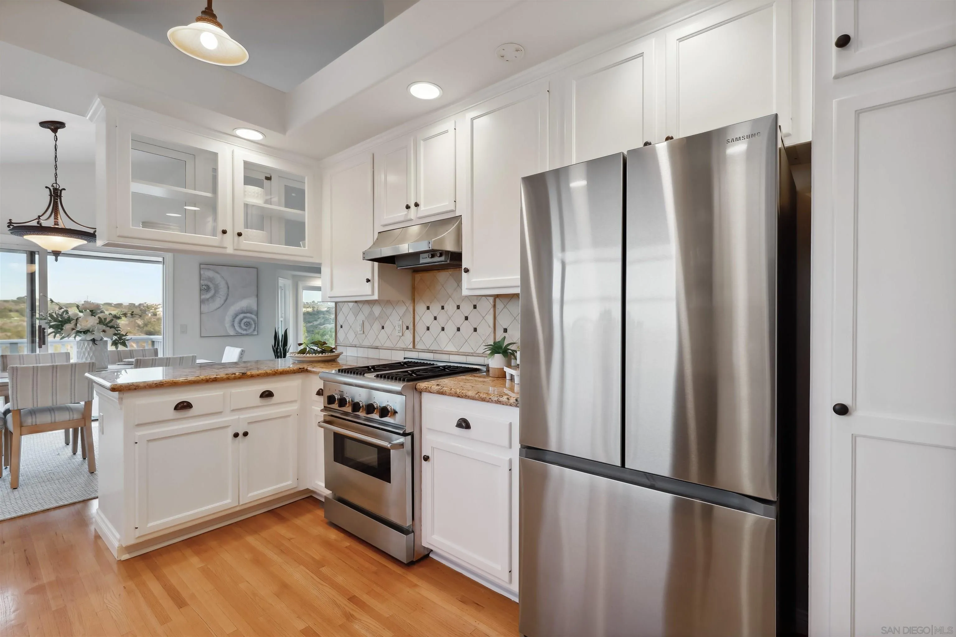 1449 Rainbow Ridge Lane Encinitas, CA 92024 - Photo 14 of 58 a kitchen with stainless steel appliances a refrigerator sink and cabinets