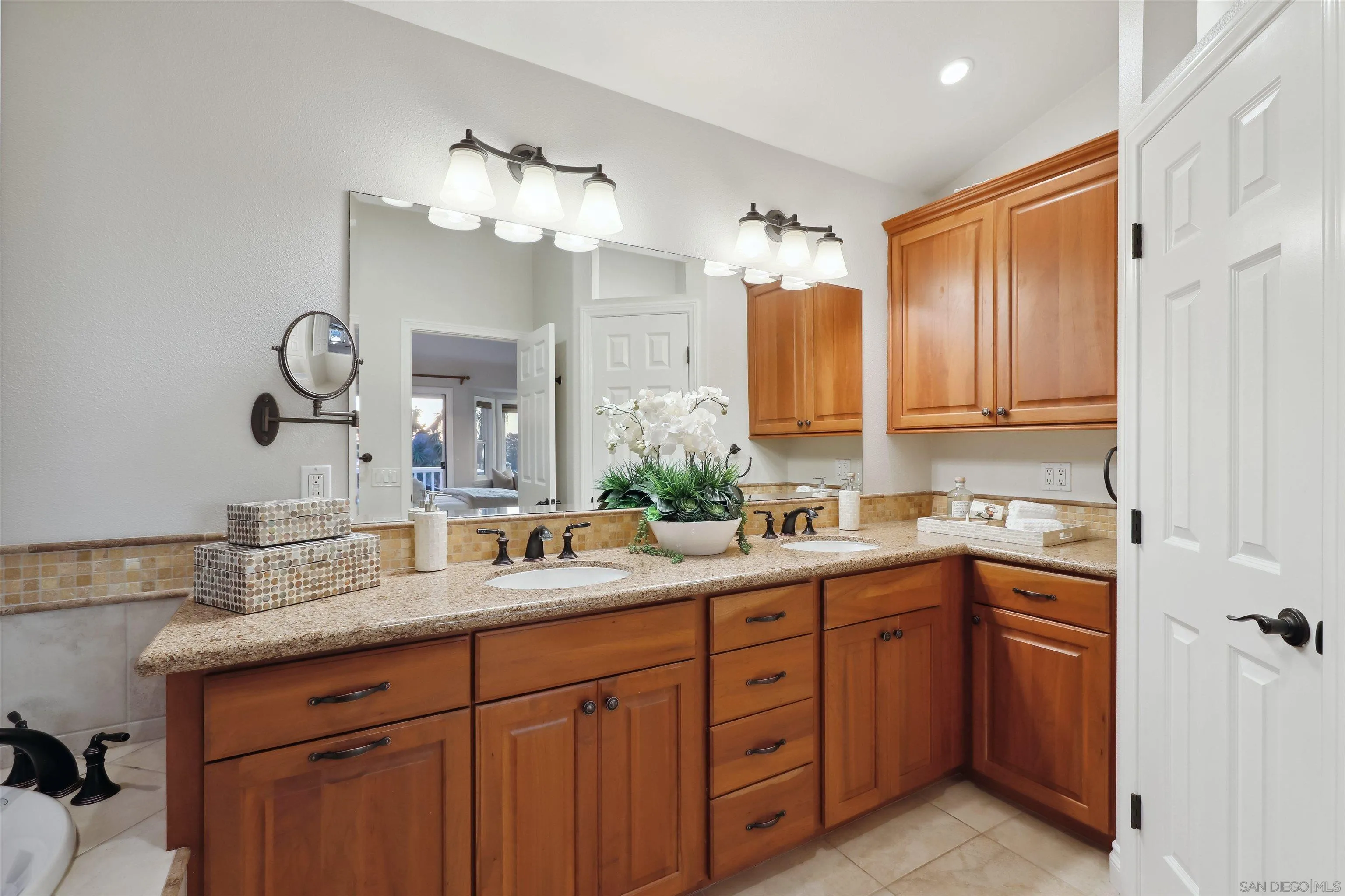 1449 Rainbow Ridge Lane Encinitas, CA 92024 - Photo 22 of 58 a bathroom with a granite countertop sink and a mirror